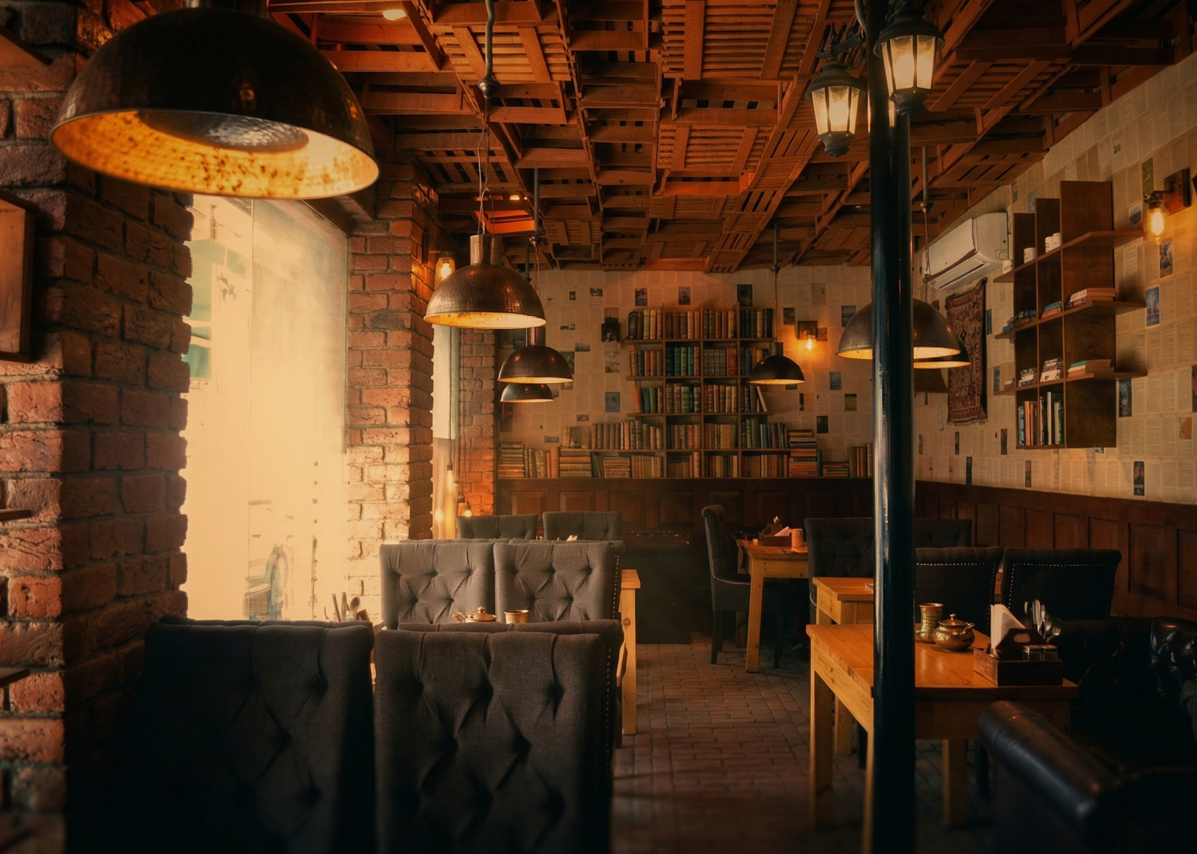 Books and Bricks Cafe interior in Srinagar — exposed brick, bookshelves, warm lighting